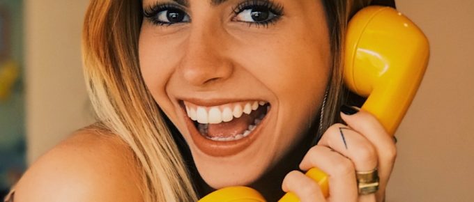 header image, smiling woman on phone