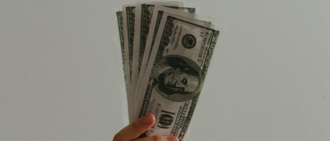 hand holding $100 bills